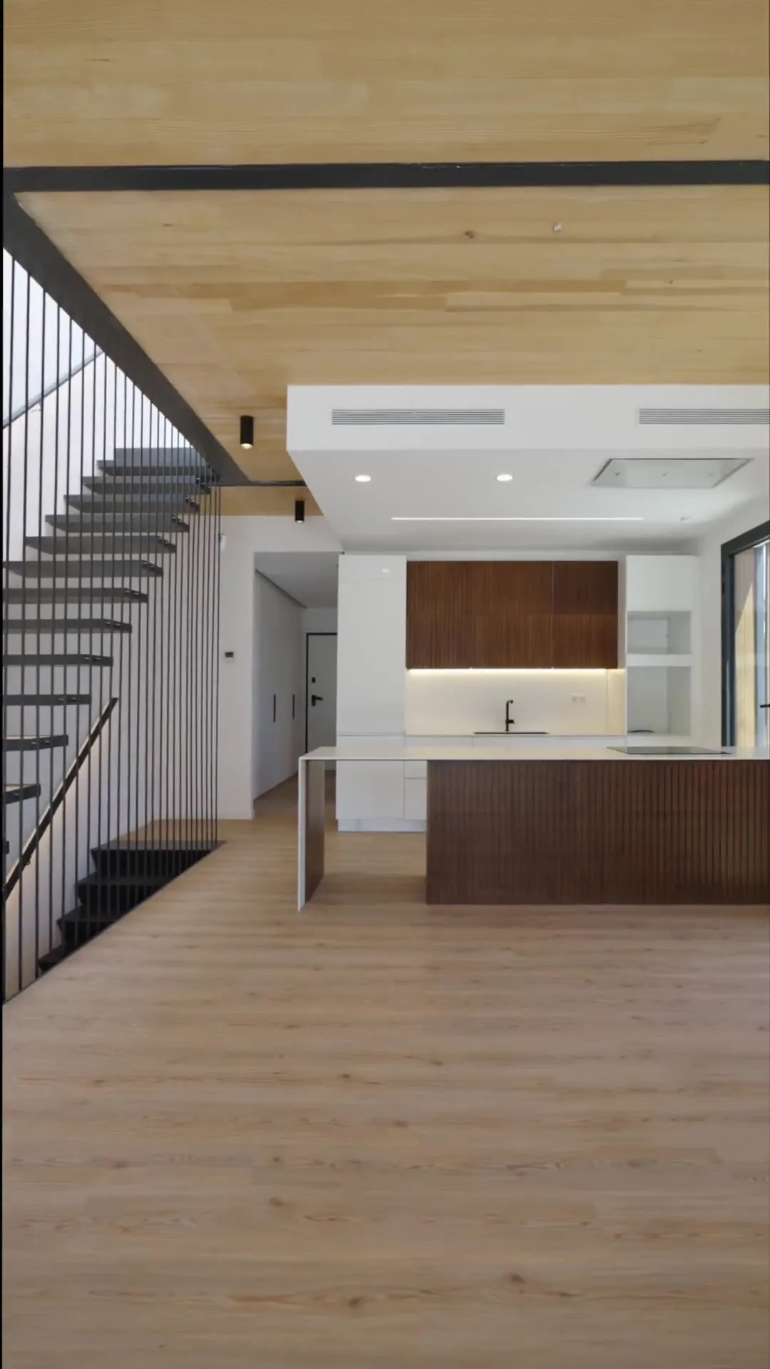 Salón con cocina abierta y techo de madera en una casa de Scala, en Palafolls
